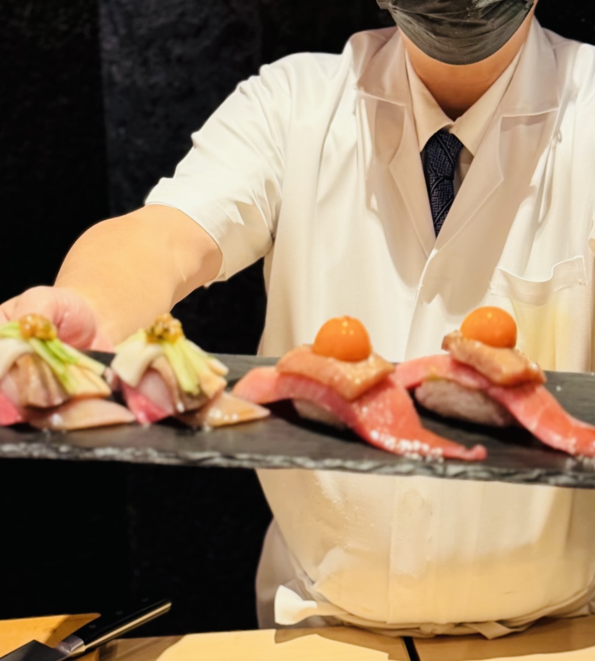 Chef presenting an artful sushi course